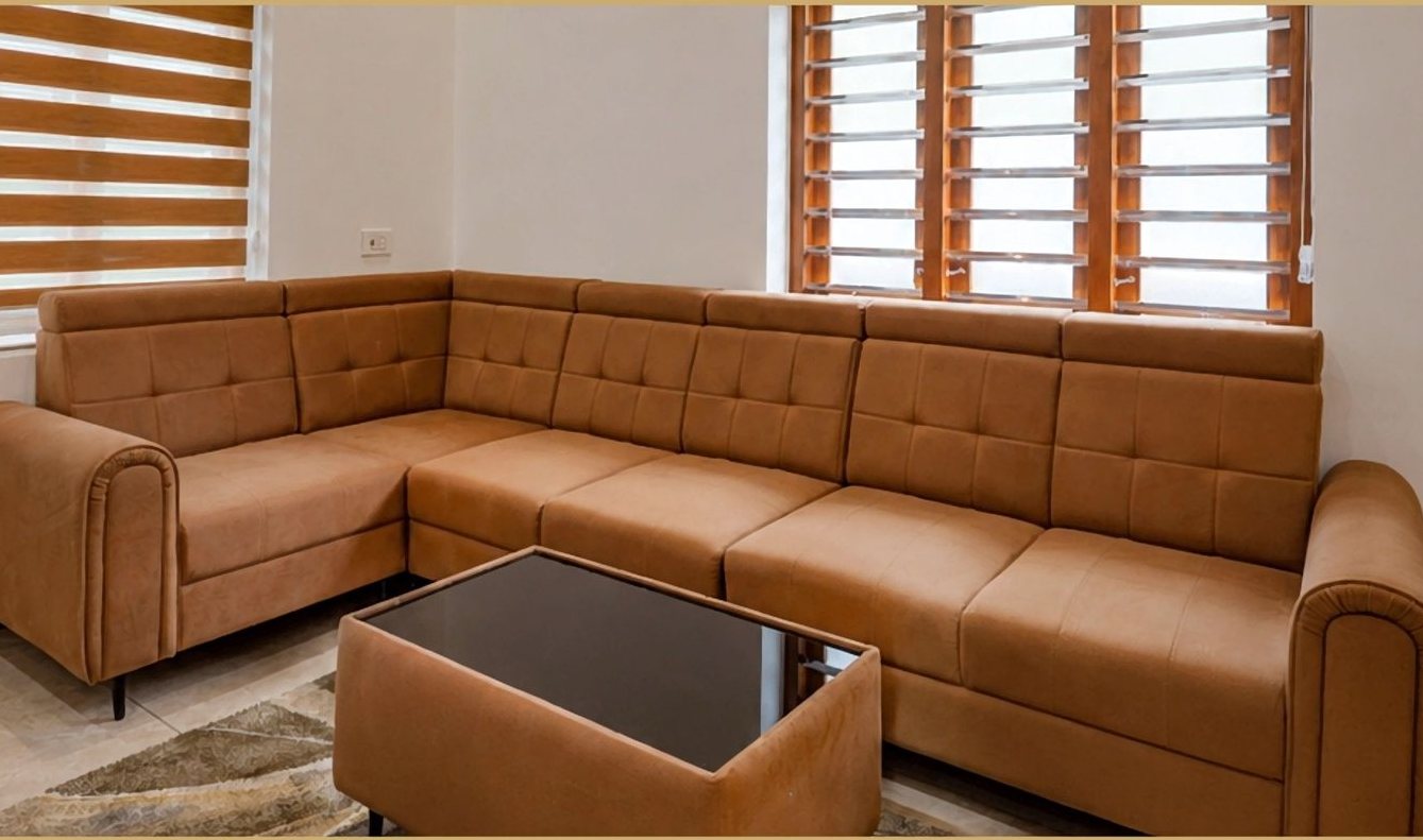 Living room of the 3 BHK villa at Skyport Villas with tan leather sectional sofa